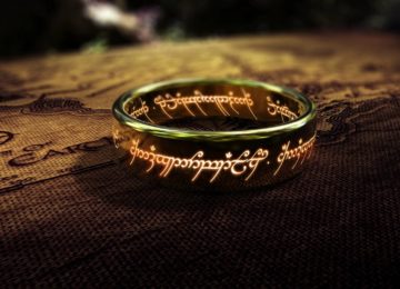 L'unico anello, oggetto principale di The Lord of the Rings, inquadrato con le scritte di fuoco lungo la fascia, adagiato su una cartina della Terra di Mezzo